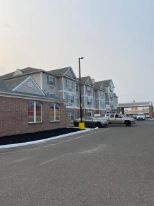 a row of houses with cars parked in a parking lot at Homestead Lodge Apart Hotel in Pleasantville