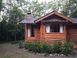 una cabaña de madera con chimenea encima en Cabaña Odila en Villa Ventana