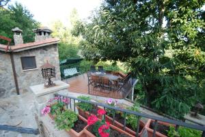 un patio con mesa, sillas y flores en Posada Real Ruralmusical en Puerto de Béjar