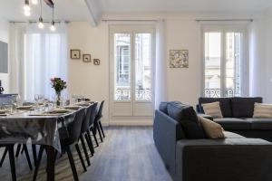 a dining room with a table and chairs and a room with at LE DIVILLIEN - Bel et grand appartement idéalement situé in Marseille