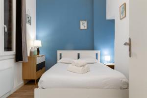 a blue bedroom with a bed with two towels on it at LE DIVILLIEN - Bel et grand appartement idéalement situé in Marseille