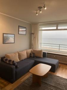 a living room with a blue couch and a table at Strandhotel Wohnung 69 in Dahme