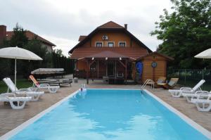 a swimming pool with chairs and a house at Lifestyle Balaton in Siófok