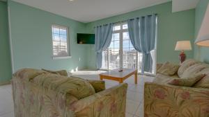 a living room with two couches and a large window at Americana Princess Suites/Condos in Ocean City