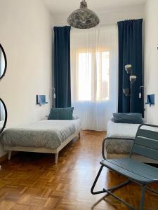 een kamer met 2 bedden en een stoel. bij B&B Monteverdi L'Arancio in Florence