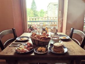 a wooden table with breakfast food on it at Auberge de Chanteuges in Chanteuges