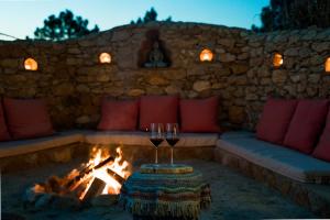 two glasses of wine sitting next to a fire pit at EcoNature Dagaio Handmade Paradise in Ericeira