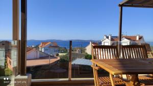 a balcony with a wooden table and a view of the ocean at Apartamentos Aqualecer in Aios