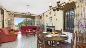 een woonkamer met een tafel, stoelen en een open haard bij 2inma01 - Lloret de Mar in Lloret de Mar