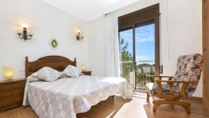 een slaapkamer met een bed, een stoel en een raam bij 2inma01 - Lloret de Mar in Lloret de Mar +31 foto's