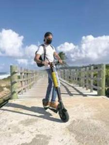 a man standing on a scooter on a bridge at Haudimar PH Beachfront Apt 4BR/3Bath in Isabela
