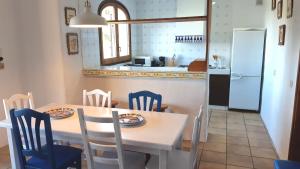 een keuken met een tafel en stoelen en een keuken met een koelkast bij 2ibi - Lloret de mar in Lloret de Mar