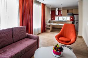 a living room with a couch and an orange chair at Hotel Plaza Suites in Bogotá
