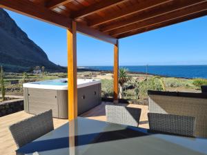 un patio con tavolo, sedie e vista sull'oceano di Casa Tabaiba Dulce a Frontera