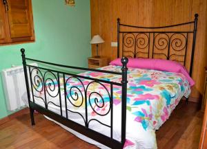 a bedroom with a bed with a colorful comforter at Pedrazales Rural in Pedrazales