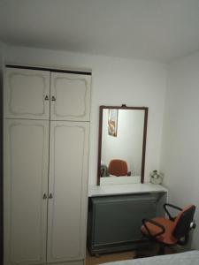 - une chambre avec un miroir, une commode et une chaise dans l'établissement Keti 2, à Belgrade