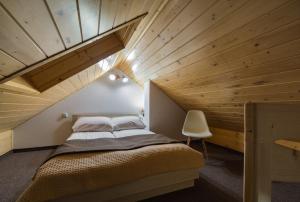a bed in a room with a wooden ceiling at Willa Lala in Szczawnica