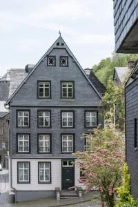 une grande maison en noir et blanc avec une porte noire dans l'établissement Boutique Fachwerkhaus Thirty Five, à Monschau