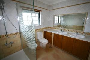 y baño con aseo, lavabo y ducha. en Villa Vista Mar Piscina Suites, en Fuseta
