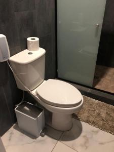 a bathroom with a toilet with a roll of toilet paper on it at Hotel Finca San Nicolas in San Salvador