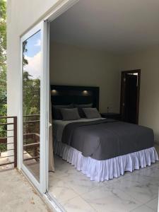 a bedroom with a bed and a sliding glass door at Hotel Finca San Nicolas in San Salvador