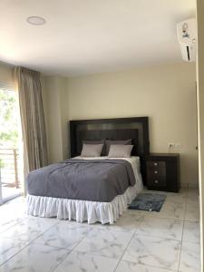 a bedroom with a large bed with a marble floor at Hotel Finca San Nicolas in San Salvador