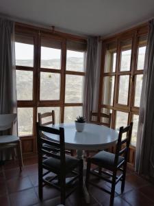 uma mesa e cadeiras num quarto com uma janela em Casa La Pizarra em Bubión