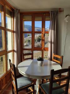 a table and chairs in a room with a window at Casa La Pizarra in Bubión