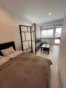 een slaapkamer met een bed en een bank erin bij Akmene Center Apartment in Naujoji Akmenė