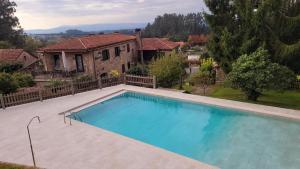 a large swimming pool in front of a house at Casa de Casal in Lestedo