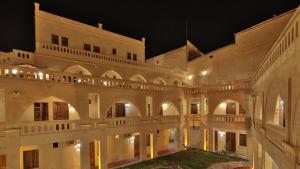 a large building with a courtyard at night at Dilek Kaya Hotel in Ortahisar