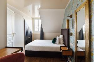 a bedroom with a bed and a mirror at Moris Grands Boulevards in Paris