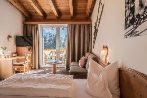 Cet appartement comprend une chambre avec un lit et un salon avec un bureau. dans l'établissement Sweet Cherry - Boutique & Guesthouse Tyrol, à Innsbruck