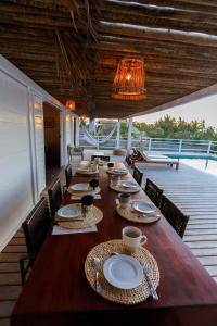 a long wooden table with chairs and plates on it at Villa Tomama by Preabeach Experience in Prea