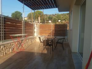 a patio with a table and chairs on a balcony at Nereids Apartments-Pronoe in Petalidi