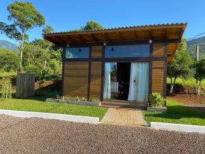 a small house with a large glass door at Cabana Flor de Cactos in Praia Grande