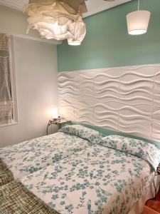 um quarto com uma cama com colcha floral em Apartamento La Muralla parking gratis em Burgos