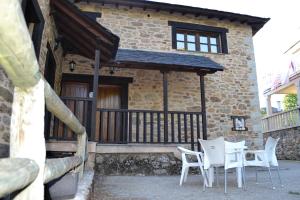 une table et des chaises devant un bâtiment dans l'établissement Pedrazales Rural, à Pedrazales