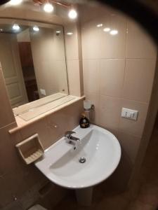 un bagno con un lavandino bianco e uno specchio di casa torre di ligny a Trapani