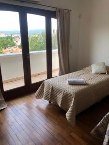 サルタにあるDepartamento zona residencial CON PILETAのベッドルーム1室(ベッド1台、大きな窓付)