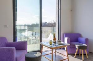 sala de estar con sillas de color púrpura y mesa en Loft a Montepulciano sopra Birrificio artigianale, en Abbadia a Isola