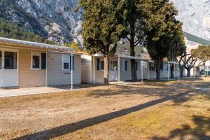 a row of houses in front of a mountain at Camping Daino in Pietramurata