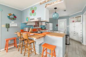 a kitchen with blue walls and orange bar stools at My Tybee Queen in Tybee Island