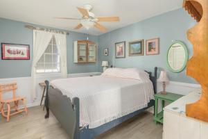 una camera con letto e ventilatore a soffitto di My Tybee Queen a Tybee Island