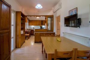 una cucina e una sala da pranzo con tavolo in legno di pension holidays studios a Vassiliki