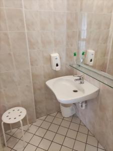 bagno con lavandino bianco e sgabello di Hotel Michelangelo a Bellaria-Igea Marina
