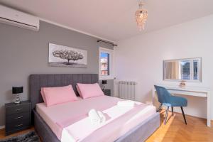 a bedroom with a large bed and a blue chair at Villa M&M - ZF Hvar in Hvar