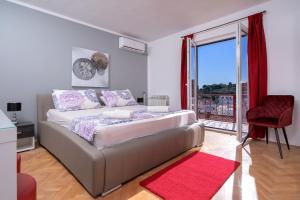 a bedroom with a large bed with a red rug at Villa M&M - ZF Hvar in Hvar