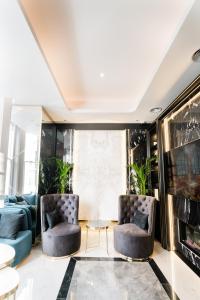 Merit Kensington Hotel في لندن: غرفة معيشة مع كرسيين وطاولة