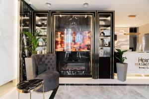 a living room with a chair and a fireplace at Merit Kensington Hotel in London